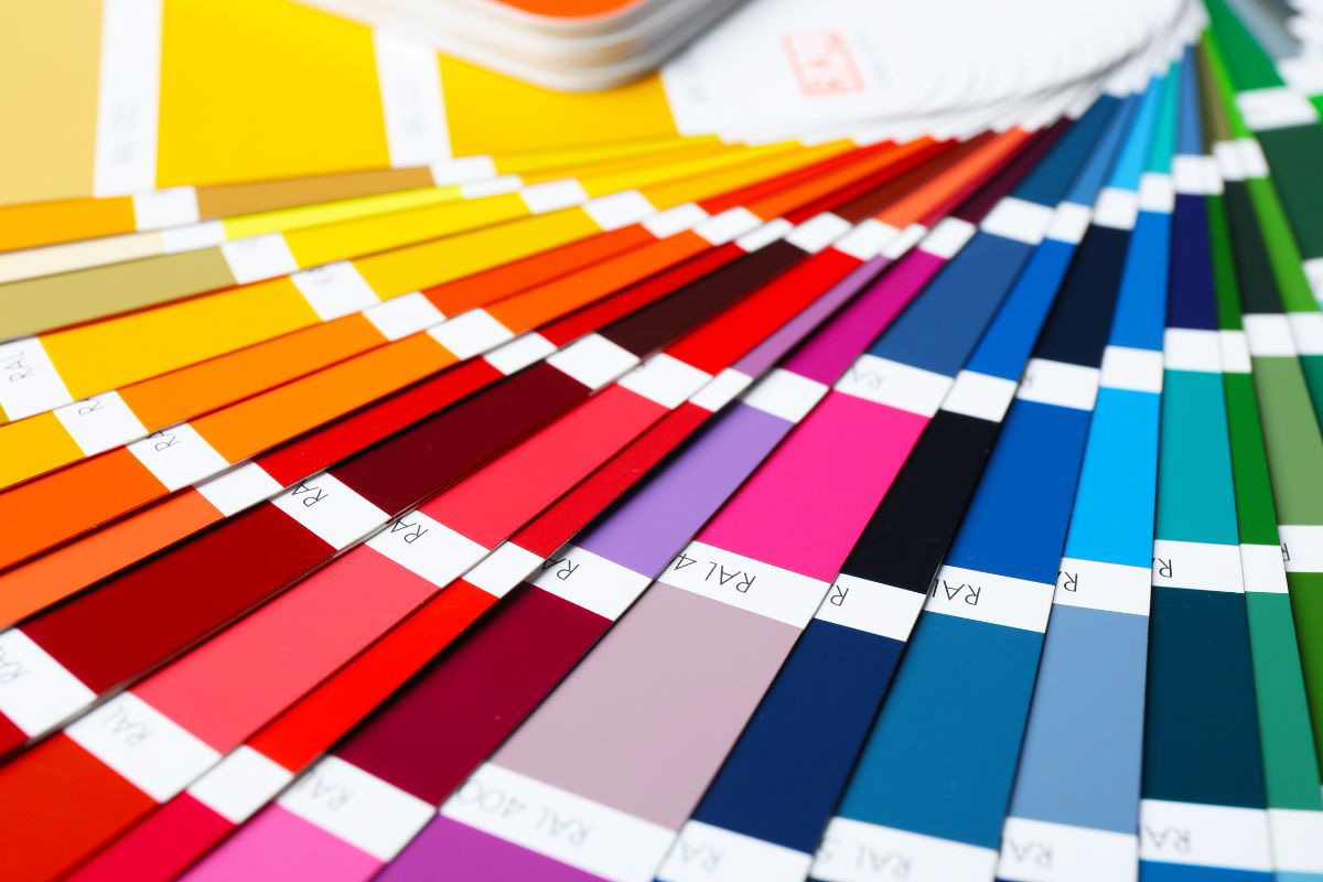 Close-up of a RAL colour fan deck showing a wide range of colour swatches from yellow and red to blue and green, used for design and printing colour matching.